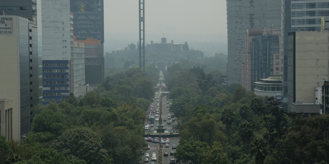 CORRECTS DATE - Smoke and pollution hangs over in Mexico City's iconic Reforma Avenue and Chapultepec Castle, Tuesday, May 14, 2019. Mexico City has declared a pollution emergency over smoke from brushfires that has cast a pall over the city of 9 million. The measure is not accompanied by the usual driving restrictions because this time the pollution isn't coming from cars. The city's pollution alerts are usually triggered by high ozone levels. (AP Photo/Gerardo Carrillo)