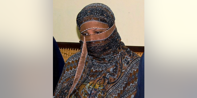 FILE - In this Nov. 20, 2010, file photo, Aasia Bibi, a Pakistani Christian woman, listens to officials at a prison in Sheikhupura near Lahore, Pakistan. Pakistani media say Aasia Bibi, a Christian woman acquitted of blasphemy after spending eight years on death row, has left Pakistan for Canada to be reunited with her daughters. Wilson Chawdhry of the British Pakistani Christian Association told The Associated Press on Wednesday, May 8, 2019, he received a telephone text message from a British diplomat stating simply that “Aasia is out.” (AP Photo, File)