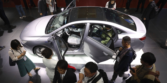 FILE - In this April 16, 2019, file photo, Chinese automaker Geely Auto displays a sedan from its new electric brand Geometry during the Auto Shanghai 2019 show in Shanghai. China's auto sales sank 17.7% in April from a year earlier, the 10th straight month of decline amid trade tension with Washington and an economic slowdown. (AP Photo/Ng Han Guan, File)