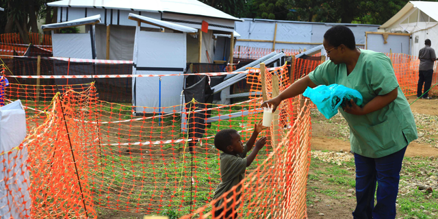 In this Sunday, Sept. 9, 2018 file photo, a health worker feeds a boy suspected of having the Ebola virus at an Ebola treatment center in Beni, Eastern Congo.