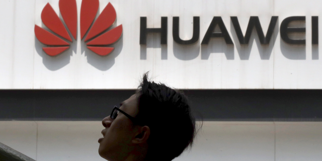 In this photo taken Thursday, May 16, 2019, a man past by a Huawei store in Beijing. Google is assuring users of Huawei smartphones the American company's services still will work on them following U.S. government restrictions on doing business with the Chinese tech giant. (AP Photo/Ng Han Guan)