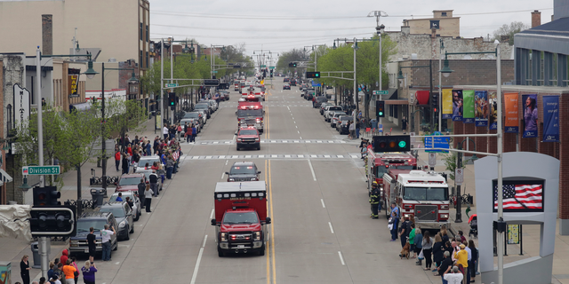 In this Thursday, May 16, 2019 photo, a procession for firefighter Mitch Lundgaard who was shot and killed while responding to a medical call at the Valley Transit Center moves along College Avenue in Appleton, Wis. (Dan Powers/The Post-Crescent via AP)