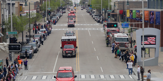 In this Thursday, May 16, 2019 photo, a procession for firefighter Mitch Lundgaard who was shot and killed while responding to a medical call at the Valley Transit Center moves along College Avenue in Appleton, Wis. (Dan Powers/The Post-Crescent via AP)