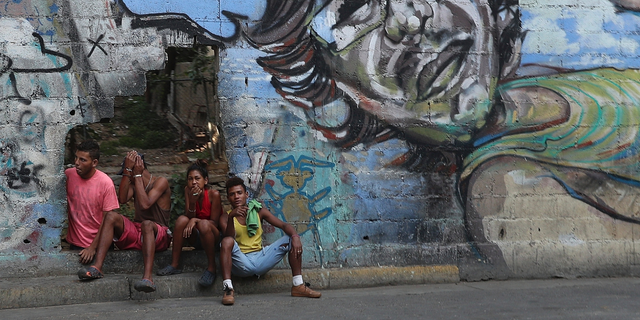 A group of young people rest in a hole in the wall at the Agua Salud neighborhood of Caracas, Venezuela, Wednesday, May 15, 2019. More than 3 million Venezuelans have left their homeland in recent years amid skyrocketing inflation and shortages of food and medicine. U.S. administration officials have warned that 2 million more are expected to flee by the end of the year if the crisis continues in the oil-rich nation. (AP Photo/Martin Mejia)