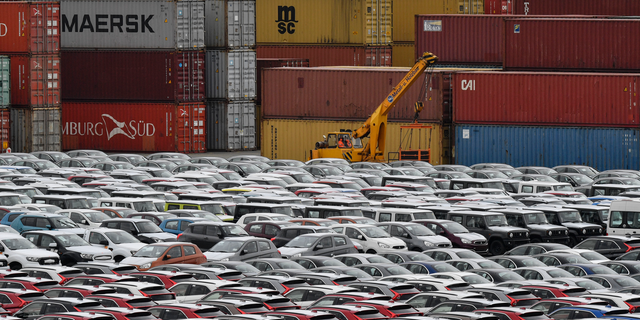 Cars for export and import are stored in front of containers on Thursday, May 16, 2019 at the harbor in Bremerhaven, Germany, with 2 million vehicles per annum one of the largest automobile hubs in the world. US President Donald Trump is delaying any decision to impose tariffs on car and auto-part imports for now. (AP Photo/Martin Meissner)