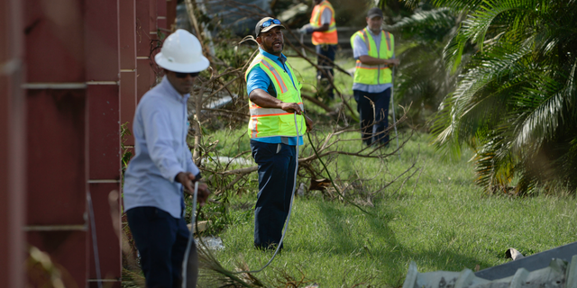 FILE - In this Sept. 23, 2017 file photo, personnel from Liberty Cable work to restore fiber optic lines on the third day after the impact of Maria, a Category 5 hurricane that crossed the island, in Carolina, Puerto Rico. A report issued Tuesday, May 13, 019, by the group Free Press, a consumer activist group, is calling on the U.S. government to investigate the collapse of communications in Puerto Rico after Hurricane Maria to avoid a repeat of the situation as the island prepares for another storm season. (AP Photo/Carlos Giusti, File)