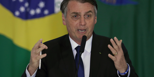 Brazil's President Jair Bolsonaro speaks during a ceremony where he signed a second decree that eases gun restrictions, during the signing ceremony at Planalto presidential palace in Brasilia, Brazil, Tuesday, May 7, 2019. The decree opens Brazil’s market to guns and ammunition made outside of Brazil according to a summary of the decree. Gun owners can now buy between 1,000 -5,000 rounds of ammunition per year depending on their license, up from 50 rounds. Lower-ranking military members can now carry guns after 10 years of service. (AP Photo/Eraldo Peres)