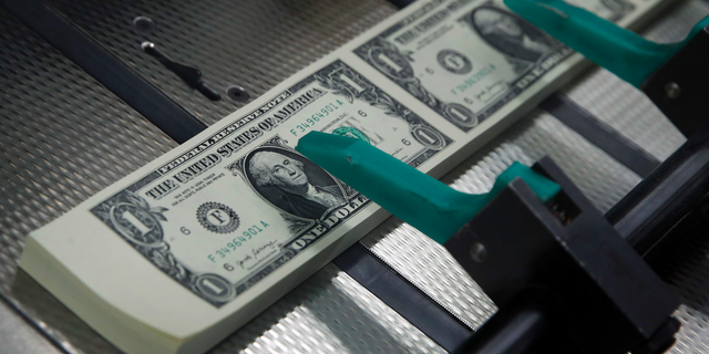FILE- In this Nov. 15, 2017, file photo, new $1 bills with the signatures of U.S. Treasurer Jovita Carranza and Treasury Secretary Steven Mnuchin are cut and stacked at the Bureau of Engraving and Printing in Washington. Last year’s scary tumble for the stock market wasn’t enough to scare workers off of saving for retirement. Instead, many ended up saving more. During the first quarter of this year, the average worker set aside a record $2,370, according to Fidelity Investments. Including employer contributions, workers saved an average of 13.5% of their pay during the first three months of 2019. That’s the closest they’ve ever come to Fidelity’s recommendation of 15%. (AP Photo/Jacquelyn Martin, File)
