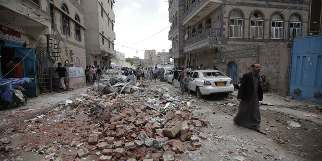 People inspect the site of an airstrike by Saudi-led coalition forces, in Sanaa, Yemen, Thursday, May, 16, 2019. Yemen's human rights minister says heavy fighting is underway in the country's south as rebel Houthis push to gain more territory from government forces and their allies. The clashes come as the Saudi-led coalition carried out airstrikes on the capital, Sanaa, earlier on Thursday, targeting the Houthis and killing at least three civilians. (AP Photo/Hani Mohammed)