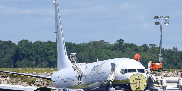 A charter plane carrying 143 people and traveling from Cuba to north Florida sits in a river at the end of a runway, Saturday, May 4, 2019 in Jacksonville, Fla. The Boeing 737 arriving at Naval Air Station Jacksonville from Naval Station Guantanamo Bay, Cuba, with 136 passengers and seven aircrew slid off the runway Friday night into the St. Johns River, a NAS Jacksonville news release said. (AP Photo/Gary McCullough)