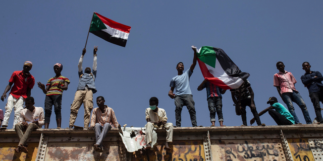 Sudanese protesters wave national flags at the sit-in outside the military headquarters, in Khartoum, Sudan, Thursday, May 2, 2019. Sudan's protesters are holding a mass rally to step up pressure on the military to hand power to civilians following last month's overthrow of President Omar al-Bashir. (AP Photos/Salih Basheer)