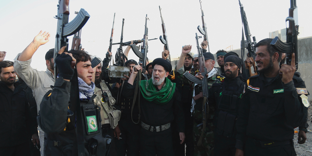 FILE - In this March 14, 2015 file photo, Iraqi Shiite militia group called Imam Ali Brigades chant slogans against the Islamic State group at the battlefield in Tikrit, 130 kilometers (80 miles) north of Baghdad, Iraq. From Lebanon and Syria to Iraq, Yemen, and the Gaza Strip, Iran has significantly expanded its footprint over the past decade, finding and developing powerful allies in conflict-ravaged countries across the Middle East. Iran has trained, financed, and equipped Shiite militias in Iraq that battled U.S. forces in the years after the 2003 invasion and remobilized to battle the Islamic State group a decade later. (AP Photo/Khalid Mohammed, File)