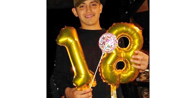 In this December 2018 photo provided by Lorena Rodriguez, Thomas Torres holds up the numbers 1 and 8 to mark his 18th birthday in Tucson, Ariz. Torres, a high school football player who has been in the U.S. since he was a toddler, was in custody for possible deportation to his native Mexico, prompting a protest Monday, May 6, 2019, by classmates outside an Arizona sheriff's office. (Lorena Rodriguez via AP)