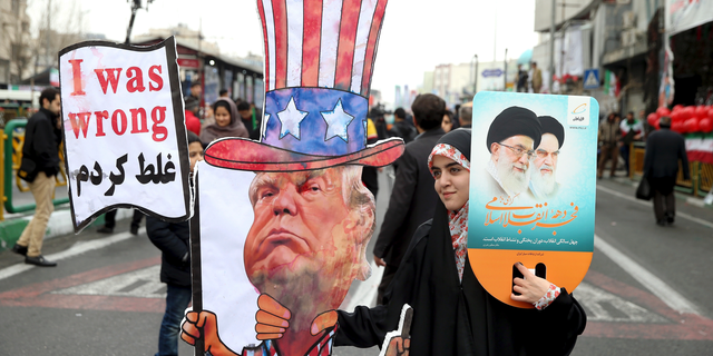 FILE - In a Feb. 11, 2019 file photo, an Iranian woman holds an effigy of US president Donald Trump, during a rally marking the 40th anniversary of the 1979 Islamic Revolution, in Tehran, Iran. Iranian President Hassan Rouhani is reportedly set to announce Wednesday, May 8, 2019, ways the Islamic Republic will react to continued U.S. pressure after President Donald Trump pulled America from Tehran’s nuclear deal with world powers. (AP Photo/Ebrahim Noroozi, File)
