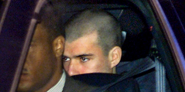 FILE - In this Jan. 24, 2002 file photo, John Walker Lindh, far right, leaves the Alexandria Detention Center in Alexandria, Va., before dawn, on the way to his first appearance in a nearby federal court. Lindh, the young Californian who became known as the American Taliban after he was captured by U.S. forces in the invasion of Afghanistan in late 2001, is set to go free Thursday, May 23, 2019, after nearly two decades in prison. (AP Photo/J. Scott Applewhite, File)