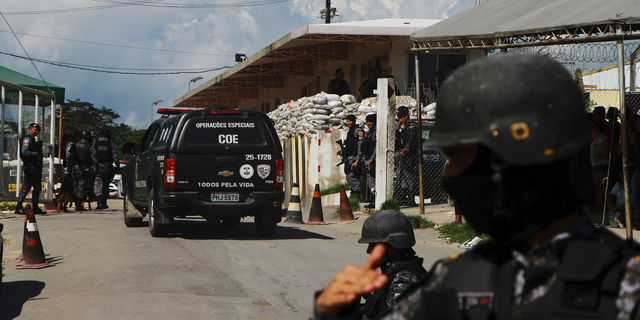 Police guarding the entrance to the Anisio Jobim Prison Complex after a deadly riot erupted among inmates in Manaus on Sunday. (AP Photo/Edmar Barros)