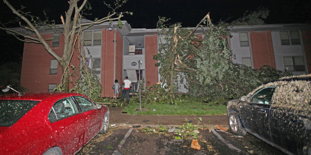 Residents walk toward their Westbrooke Village Apartment building that was heavily damaged by a tornado Tuesday morning, May 28, 2019, in Dayton, Ohio.