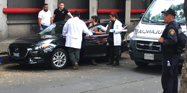 Forensic investigators examine a vehicle after the bodyguard of prominent Mexican journalist Héctor de Mauleón repelled an assault, in Mexico City, Monday, May 6, 2019. One man was killed in the attack and It was not immediately clear if de Mauleón was targeted or if it was an attempted carjacking. (AP Photo/Peter Orsi)