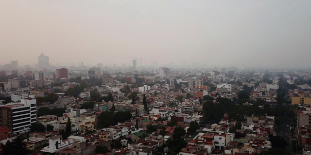 Smoke covers Mexico City, Sunday, May 12, 2019. Mexico City has warned residents to remain indoors as forest and brush fires carpet the metropolis in smoke. (AP Photo/Christian Palma)