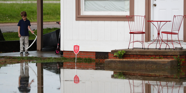 Trevor Clardy, 6, looks at flood waters outside his Pearl, Miss., Thursday, May 9, 2019. Strong winds, tornado warnings and substantial rains added to the flash flooding throughout Mississippi. (AP Photo/Rogelio V. Solis)