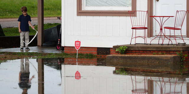 Trevor Clardy, 6, looks at flood waters outside his Pearl, Miss., Thursday, May 9, 2019. Strong winds, tornado warnings and substantial rains added to the flash flooding throughout Mississippi. (AP Photo/Rogelio V. Solis)