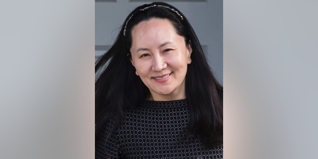 Huawei Chief Financial Officer Meng Wanzhou, who is out on bail and remains under partial house arrest after she was detained Dec. 1 at the behest of American authorities, is accompanied by a private security detail as she leaves her home to attend a court appearance in Vancouver, British Columbia, Wednesday, May 8, 2019. (Darryl Dyck/The Canadian Press via AP)
