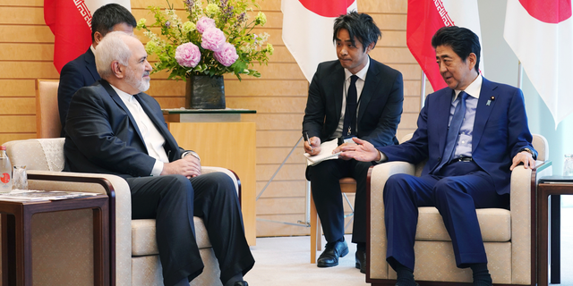 Iranian Foreign Minister Mohammad Javad Zarif, left, and Japanese Prime Minister Shinzo Abe, right, speak at Abe's official residence in Tokyo Thursday, May 16, 2019. Iran’s foreign minister has said his country is committed to an international nuclear deal and criticized escalating U.S. sanctions “unacceptable” as he met with Japanese officials in Tokyo amid rising tensions in the Middle East.(AP Photo/Eugene Hoshiko, Pool)