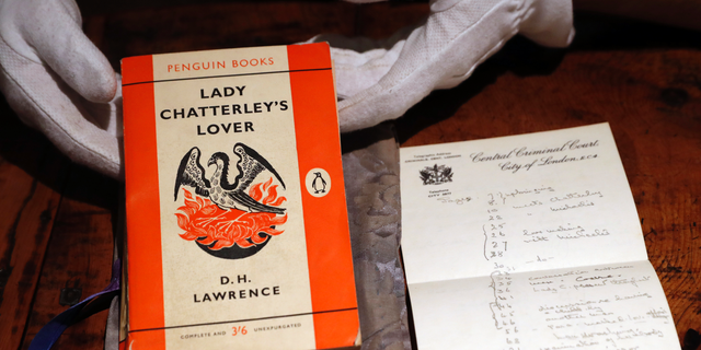 FILE - In this Friday, Oct. 26, 2018 file photo, a copy of D.H Lawrence's book "Lady Chatterley's Lover" that was the judge's personal version used in the infamous 1960 Chatterley trial, on view in Sotheby's auction house in London. The British government has on Monday, May 13, 2019 used its powers to preserve the nation’s cultural treasures to halt the export of a tattered paperback copy of “Lady Chatterley’s Lover.” The copy of the once-scandalous book was used by the judge in the U.K. obscenity trial of Penguin Books, prosecuted in 1960 for publishing D.H. Lawrence's novel about an affair between a wealthy woman and her husband's gamekeeper.(AP Photo/Alastair Grant, File)