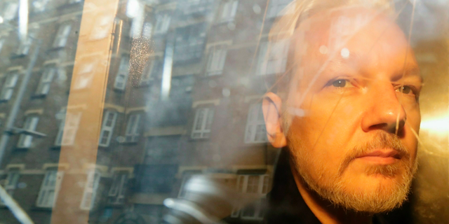 FILE - In this Wednesday May 1, 2019 file photo, buildings are reflected in the window as WikiLeaks founder Julian Assange is taken from court, where he appeared on charges of jumping British bail seven years ago, in London. Swedish prosecutors plan to decide whether they will reopen a rape case against WikiLeaks founder Julian Assange. (AP Photo/Matt Dunham)