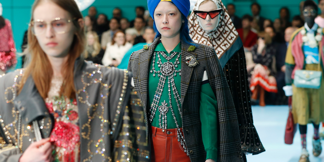 FILE - In this Feb. 21, 2018 file photo, models display items from Gucci's women's Fall/Winter 2018-2019 collection, presented during the Milan Fashion Week, in Milan, Italy. The top civil rights organization for Sikhs in the United States says Nordstrom has apologized to the community for selling an $800 turban they found offensive, but they are still waiting to hear from the Gucci brand that designed it, Saturday, May 18, 2019. (AP Photo/Antonio Calanni, File)