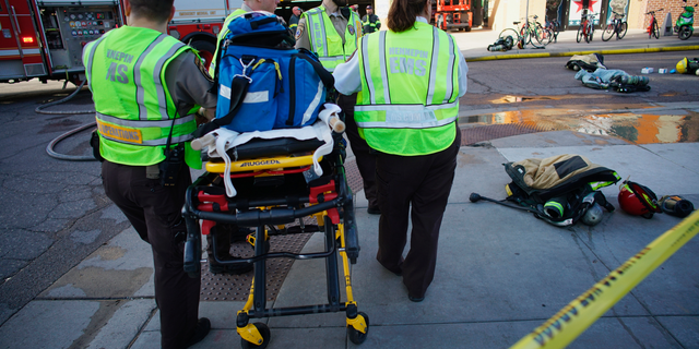 Members of an EMT team stand by as a Dinkytown apartment building was being evacuated after a report of a hazardous materials incident in Minneapolis on Tuesday, May 7, 2019. Fire crews are evacuating the residential building near the University of Minnesota because of a suspected hazardous materials incident. (Richard Tsong-Taatarii/Star Tribune via AP)