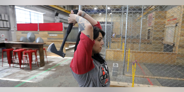 General manager Devan Watanabe throws an axe at Social Axe Throwing Wednesday, May 1, 2019, in Salt Lake City. The Utah Department of Alcoholic Beverage Control announced Tuesday, April 30, 2019, that beer will not be allowed at a Salt Lake City karaoke business or an Ogden ax-throwing venue because neither fits the 14 definitions of a "recreational amenity,"under a new law passed by Utah's Republican-controlled legislature during the yearly session that ended in March. (AP Photo/Rick Bowmer)