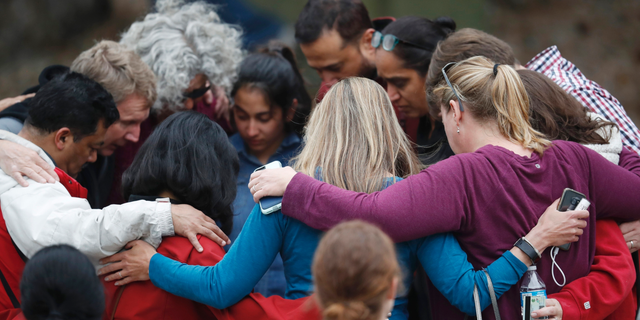 Parents gather in a circle to pray at a recreation center where students were reunited with their parents after a shooting at a suburban Denver middle school Tuesday, May 7, 2019, in Highlands Ranch, Colo. (AP Photo/David Zalubowski)