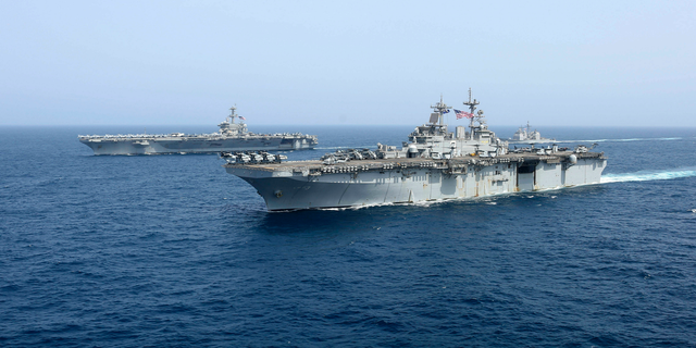 CORRECTS DATE - In this Friday, May 17, 2019, photo released by the U.S. Navy, the amphibious assault ship USS Kearsarge sails in front of the USS Abraham Lincoln aircraft carrier in the Arabian Sea. Commercial airliners flying over the Persian Gulf risk being targeted by "miscalculation or misidentification" from the Iranian military amid heightened tensions between the Islamic Republic and the U.S., American diplomats warned Saturday, May 18, 2019, even as both Washington and Tehran say they don't seek war. (Mass Communication Specialist 1st Class Brian M. Wilbur, U.S. Navy via AP)