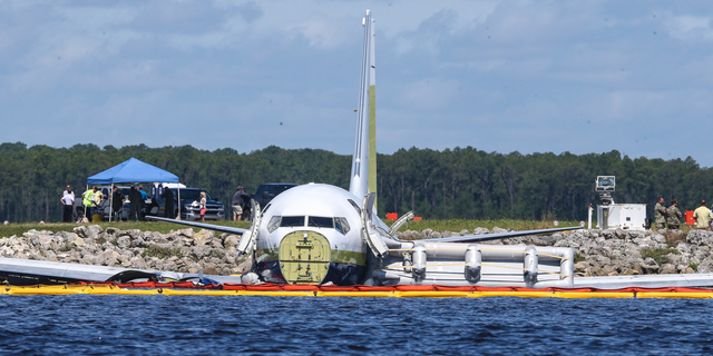 A charter plane carrying 143 people and traveling from Cuba to north Florida sits in a river at the end of a runway, Saturday, May 4, 2019 in Jacksonville, Fla. The Boeing 737 arriving at Naval Air Station Jacksonville from Naval Station Guantanamo Bay, Cuba, with 136 passengers and seven aircrew slid off the runway Friday night into the St. Johns River, a NAS Jacksonville news release said. (AP Photo/Gary McCullough)