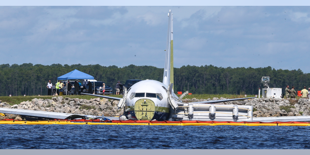 A charter plane carrying 143 people and traveling from Cuba to north Florida sits in a river at the end of a runway, Saturday, May 4, 2019 in Jacksonville, Fla. The Boeing 737 arriving at Naval Air Station Jacksonville from Naval Station Guantanamo Bay, Cuba, with 136 passengers and seven aircrew slid off the runway Friday night into the St. Johns River, a NAS Jacksonville news release said. (AP Photo/Gary McCullough)