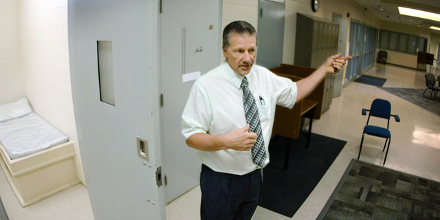 In this May 2018 photo, Tim Tausend, director of the North Dakota Youth Correctional Center, shows a look inside one of the dorm rooms inside the 25-bed Pine Cottage for high-risk male juveniles in Mandan, N.D. Authorities have charged four teenagers, including one from South Dakota, with multiple felonies in adult court in what they described as a riot earlier this year at North Dakota's youth prison. (Mike McCleary/The Bismarck Tribune via AP)