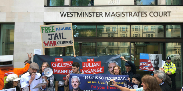 Julian Assange supporters gather outside Westminster Magistrates Court in London, Thursday May 30, 2019. Assange has missed a court session apparently due to health problems. Assange had been expected to appear from prison via video link at a brief extradition hearing Thursday at Westminster Magistrates’ Court. (Thomas Hornall/PA via AP)