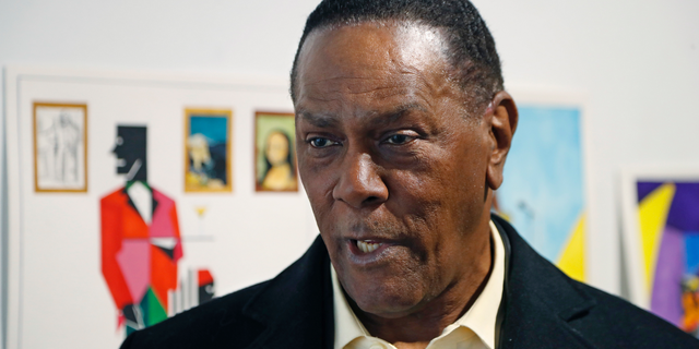 FILE - In this Jan. 17, 2019 file photo, Richard Phillips stands next to some of his artwork during an interview at the Community Art Gallery in Ferndale, Mich. Phillips was exonerated of murder in 2018 after 45 years in prison. The state of Michigan has agreed to pay $1.5 million to Phillips. The attorney general's office said Friday, May 17, 2019, it has settled a lawsuit filed Phillips. He made a claim under a Michigan law that compensates the wrongly convicted. (AP Photo/Carlos Osorio File)