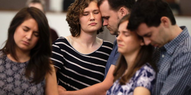 Abigail and Jonathan Dysinger, center, pray during a vigil for Donnie Johnson, Thursday, May 16, 2019, in Nashville, Tenn. Johnson was executed by lethal injection Thursday for suffocating his wife, Connie Johnson, in a Memphis camping center that he managed in 1984. The vigil was held at Riverside Seventh-Day Adventist Church, where Johnson served as an elder while in prison, even though he was never able to visit the church. (AP Photo/Mark Humphrey)