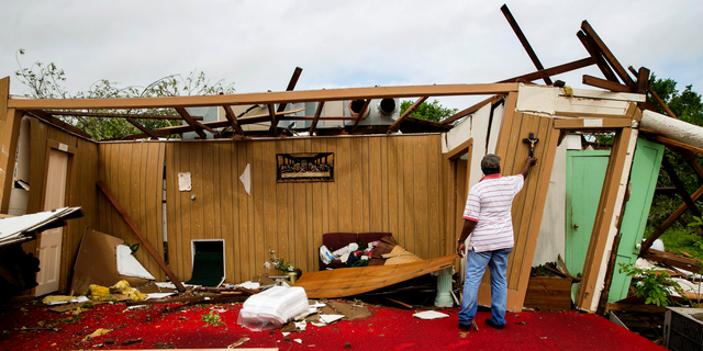 Melvin Jackson touches a cross that remained on the wall after a tornado destroyed Mt. Zion Baptist Church, a historic African American church, in La Grange, Texas, on Friday May 3, 2019. (Jay Janner/Austin American-Statesman via AP)