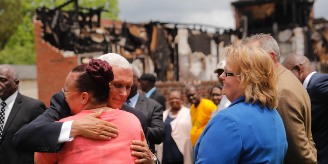 Vice President Mike Pence hugs a congregation member as he visits pastors and congregation at the Mt. Pleasant Baptist Church, which was burned along with two other nearby African American churches, in Opelousas, La., Friday, May 3, 2019. Holden Matthews, who is white, was arrested for arson and other charges in relation to the church burnings. (AP Photo/Gerald Herbert)