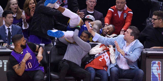 Drake, bottom left, watches as Golden State Warriors guard Andre Iguodala dives into the crowd during the first half of Game 1 of the basketball’s NBA Finals against the Toronto Raptors, Thursday, May 30, 2019, in Toronto. (Associated Press)