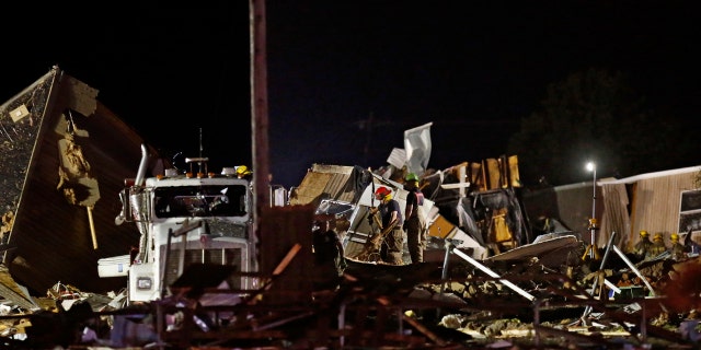 Emergency workers search through debris from a mobile home park, Sunday, May 26, 2019, in El Reno, Ok.