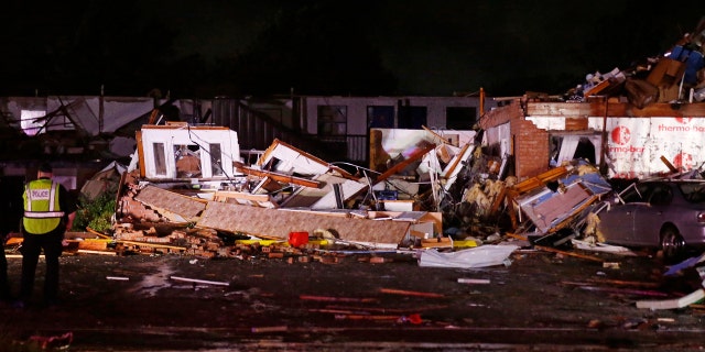 Police stand at the ruins of a hotel in El Reno, Okla., Sunday, May 26, 2019, following a tornado touchdown late Saturday night.