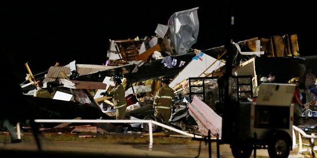 Emergency workers search through debris from a mobile home park, Sunday, May 26, 2019, in El Reno, Ok., following a tornado touchdown late Saturday night.
