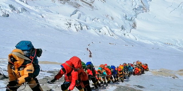 In this May 22, 2019 photo, a long queue of mountain climbers line a path on Mount Everest just below camp four, in Nepal.