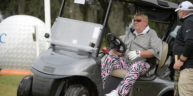 In this archival photo of December 15, 2018, John Daly leads into his basket after taking a tee shot on the 10th hole in the first round of the Father-Son Challenge golf tournament in Orlando, Florida. 