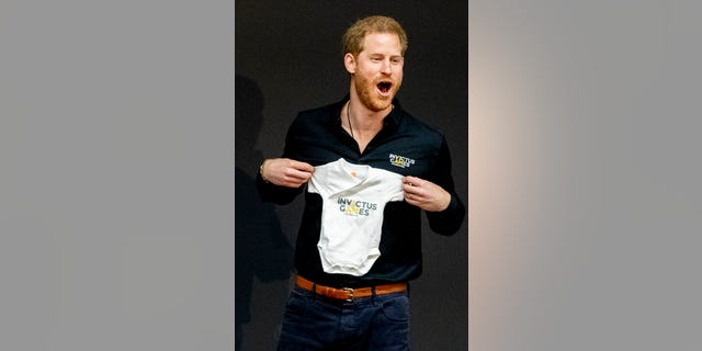 Prince Harry, Duke of Sussex is presented with an Invictus Games baby grow for his newborn son Archie during the launch of the Invictus Games on May 9, 2019 in The Hague, Netherlands