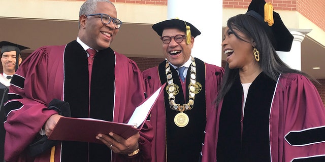Robert F. Smith, left, laughs with David Thomas, center, and actress Angela Bassett at Morehouse College on Sunday, May 19, 2019, in Atlanta. Smith, a billionaire technology investor and philanthropist, said he will provide grants to wipe out the student debt of the entire graduating class at Morehouse College - an estimated $40 million.